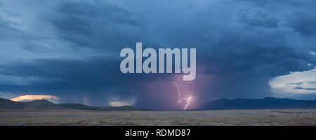 Lightning and heavy rain at dusk over mountains and grasslands in the  remote Bootheel Region of New Mexico during the Summer Monsoon Season Stock Photo