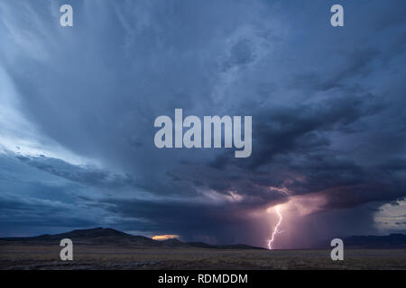 Lightning and heavy rain at dusk over mountains and grasslands in the  remote Bootheel Region of New Mexico during the Summer Monsoon Season Stock Photo