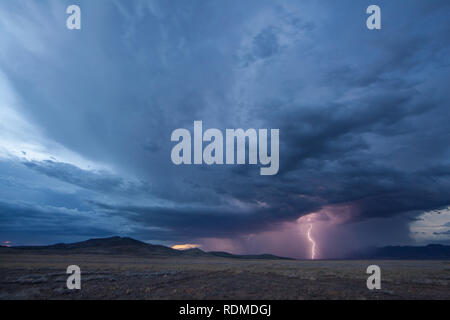 Lightning and heavy rain at dusk over mountains and grasslands in the  remote Bootheel Region of New Mexico during the Summer Monsoon Season Stock Photo