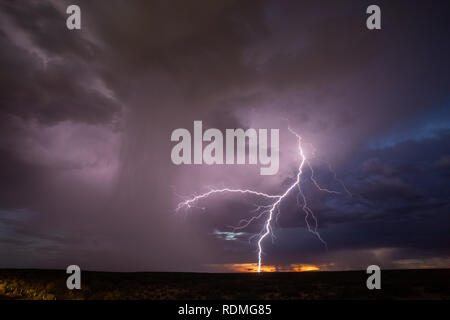 Lightning and a rain shaft from a thunderstorm after sunset in Santa Teresa New Mexico Stock Photo