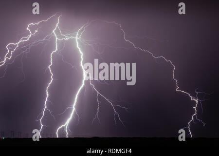 Multiple branches of cloud to ground lightning strike near high tension power lines Stock Photo