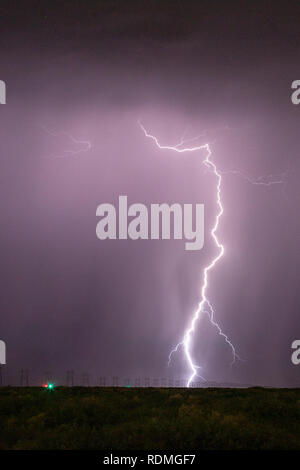 Cloud to ground lightning strikes near high tension power lines Stock Photo