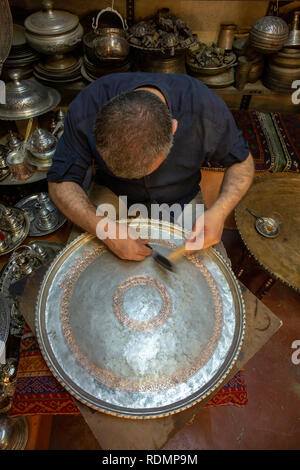 Gaziantep, Turkey - June 07, 2014: Craftsman work on a copper tray in Bakircilar Bazaar of Gaziantep, Turkey on June 07, 2014. Stock Photo