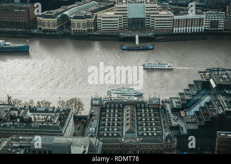 London, UK - January 13, 2019: City cruise boats on the Thames, view from above. River cruises are very popular with tourists all year around. Stock Photo