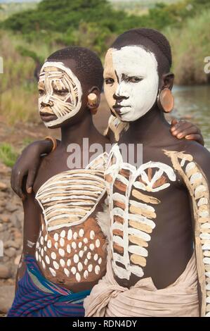 Two Surma girls with facial and body painting and ear plates, Kibish, Omo River Valley, Ethiopia, Africa Stock Photo