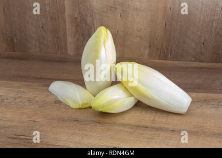 Fresh endive (Cichorium endivia)  on natural wooden background with highlight and shadows Stock Photo