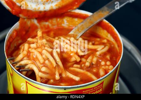 Reheating an instant meal in a tin can in a water bath, Spaghetti Bolognese Stock Photo