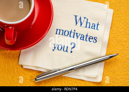 What motivates you? Hadwriting on a napkin with a cup of coffee Stock Photo