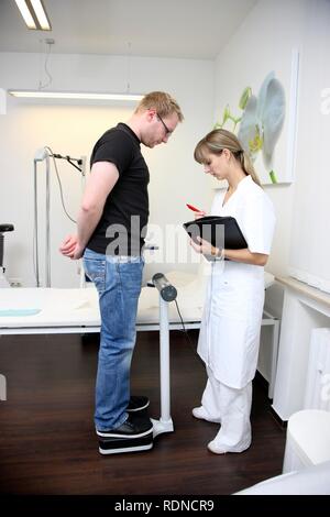 Medical practice, weighing in a patient Stock Photo