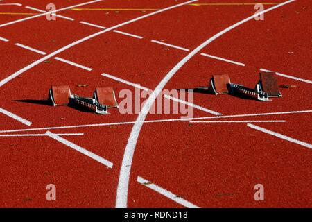 Tartan track of a sports field, starting blocks for sprinting disciplines, lane markings Stock Photo