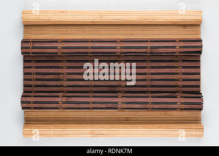 Bamboo mat with curled edges on white background. View from above Stock Photo