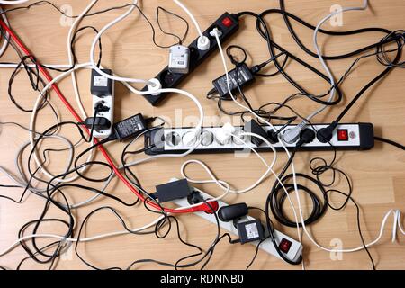Multiple power strips for connection of multiple electrical devices, tangle of cables, connectors and power supply units Stock Photo