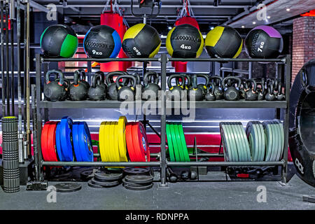 Dumbbells, pancakes and weights, leather fitballs lying on the shelves. Gym. Equipment for gym Stock Photo