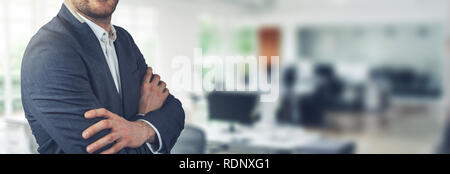 businessman standing on office background with arms crossed. copy space Stock Photo