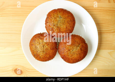 Top View of Banana Muffins on White Plate Served on Wooden Table Stock Photo