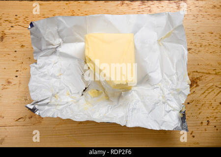 Butter in wrapper on table Stock Photo