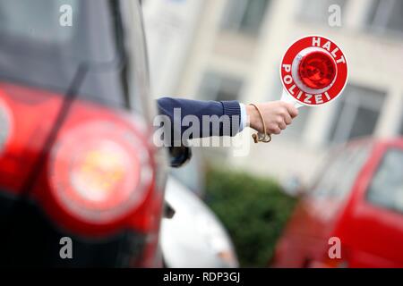 Unmarked police car, police officer stopping a vehicle with a signalling disc Stock Photo