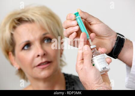 Doctor's surgery, patient having an injection with a disposable syringe, immunisation Stock Photo