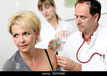 Doctor's surgery, patient having an injection with a disposable syringe, immunisation Stock Photo