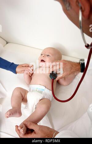 Doctor's surgery, paediatrician examining an infant, preventive medical examination, doctor listening to the baby's chest with a Stock Photo