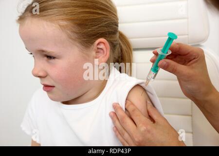 Medical practice, girl, 10 years, injection with a syringe, vaccination Stock Photo