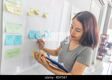 Woman checking financial data on report and the sticky notes Stock Photo