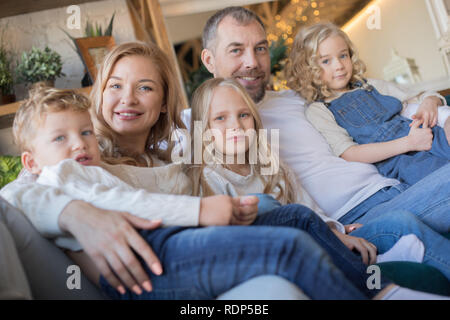 Happy family is sitting on the sofa and having fun. Stock Photo