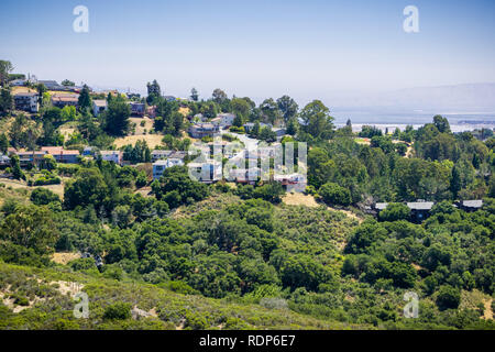 Residential neighborhood on top of a hill near Pulgas Ridge OSP, Dumbarton bridge and the bay in the background, San Carlos, San Francisco bay area, C Stock Photo