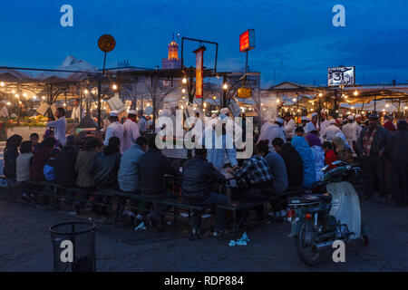 Families and tourists eating at crowded food market stalls in Marrakesh Stock Photo