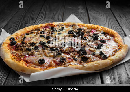 traditional italian pizza on dark wooden board, place for text Stock Photo