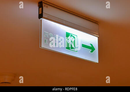 Close up of emergency exit sign write on Chinese and English word on ceiling inside shopping mall Stock Photo