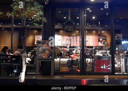 Taipei, Taiwan - December 01, 2018 : Motion of people enjoying coffee inside Starbucks coffee at night. Stock Photo