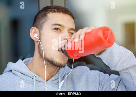 Drinking water young man runner running jogging sports training fitness outdoor Stock Photo