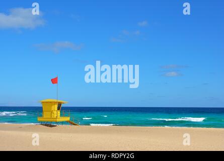 Yellow lifeguard post on the beach of Corralejo, Fuerteventura, Spain. Golden sands, cloudy blue sky and turquoise ocean. Stock Photo