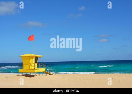 Yellow lifeguard post on the beach of Corralejo, Fuerteventura, Spain. Golden sands, cloudy blue sky and turquoise ocean. Stock Photo