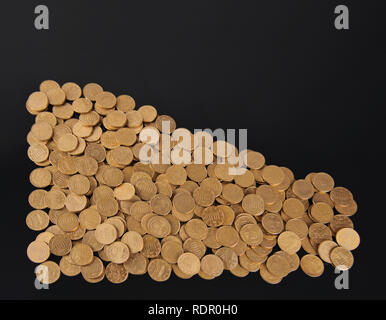 Several golden cent coins in the shape of a triangle on a black board Stock Photo