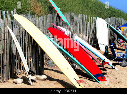 Surfboards up against a fence during a lunch break from surfing, in ditch plains Montauk, NY Stock Photo