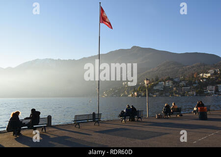 Ascona, Switzerland - December 31,  2018: People relaxing at the lakeside of Lake Maggiore Stock Photo