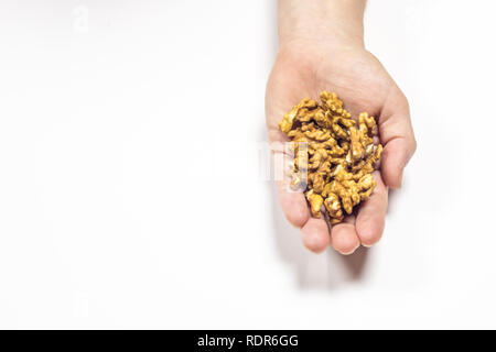 Hand holding bunch of walnuts in isolated white background. This is the recommended portion to eat everyday Stock Photo