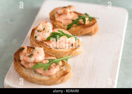 Bruschetta sandwiches with shrimps, creamy sauce and rocket salad. Stock Photo