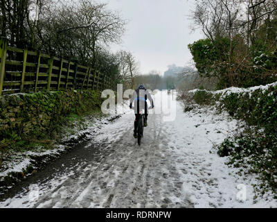UK Weather: mountain bikers enjoying the snow conditions along the High Peak Trail, Black Rocks, Bolehill, Derbyshire, Peak District National Park Credit: Doug Blane/Alamy Live News