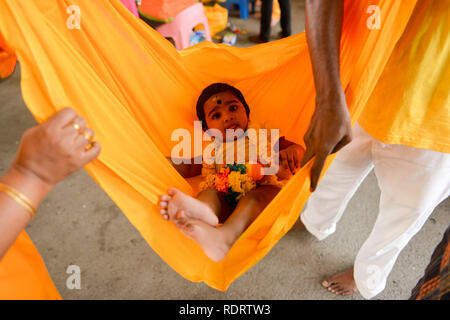 Kuala Lumpur, Kuala Lumpur, Malaysia. 19th Jan, 2019. Hindu devotees carry their baby in a sack for their pilgrimage to the sacred Batu Caves Temple during Thaipusam in Kuala Lumpur. During Thaipusam, Hindus fulfil their vows by carrying well-decorated ''˜kavadis' and pots of milk as offerings to Lord Murugan. Credit: Kepy/ZUMA Wire/Alamy Live News Credit: ZUMA Press, Inc./Alamy Live News Stock Photo