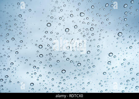 Raindrops on the windshield; in the background cloudy sky, California Stock Photo