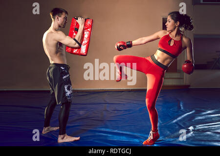 The guy and the girl work out the punches in the gym. Sport and motivation. Stock Photo