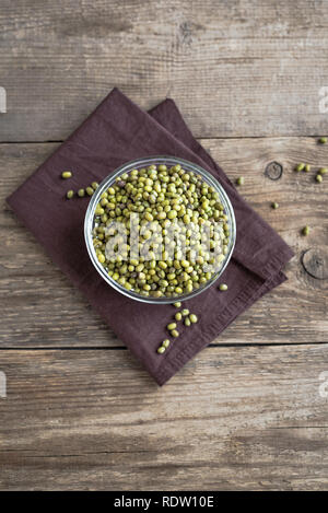 Mung beans in bowl on wooden table, ready to cook, copy space. Stock Photo
