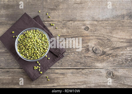 Mung beans in bowl on wooden table, ready to cook, copy space. Stock Photo