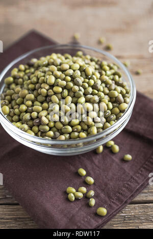 Mung beans in bowl on wooden table, ready to cook, close up. Stock Photo