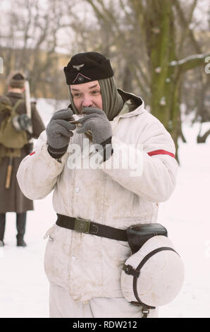 The park Ekaterinhof, St. Petersburg (Russia) - February 23, 2017: Historical reconstruction of events of World War II. German soldier with harmonica. Stock Photo