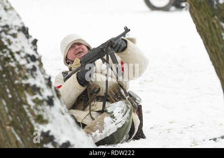 St. Petersburg, Russia - February 23, 2017: German soldier who is furiously shooting back from the automatic machine. Historical reconstruction Second Stock Photo