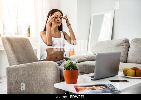 Serious young sportswoman watching video master class Stock Photo